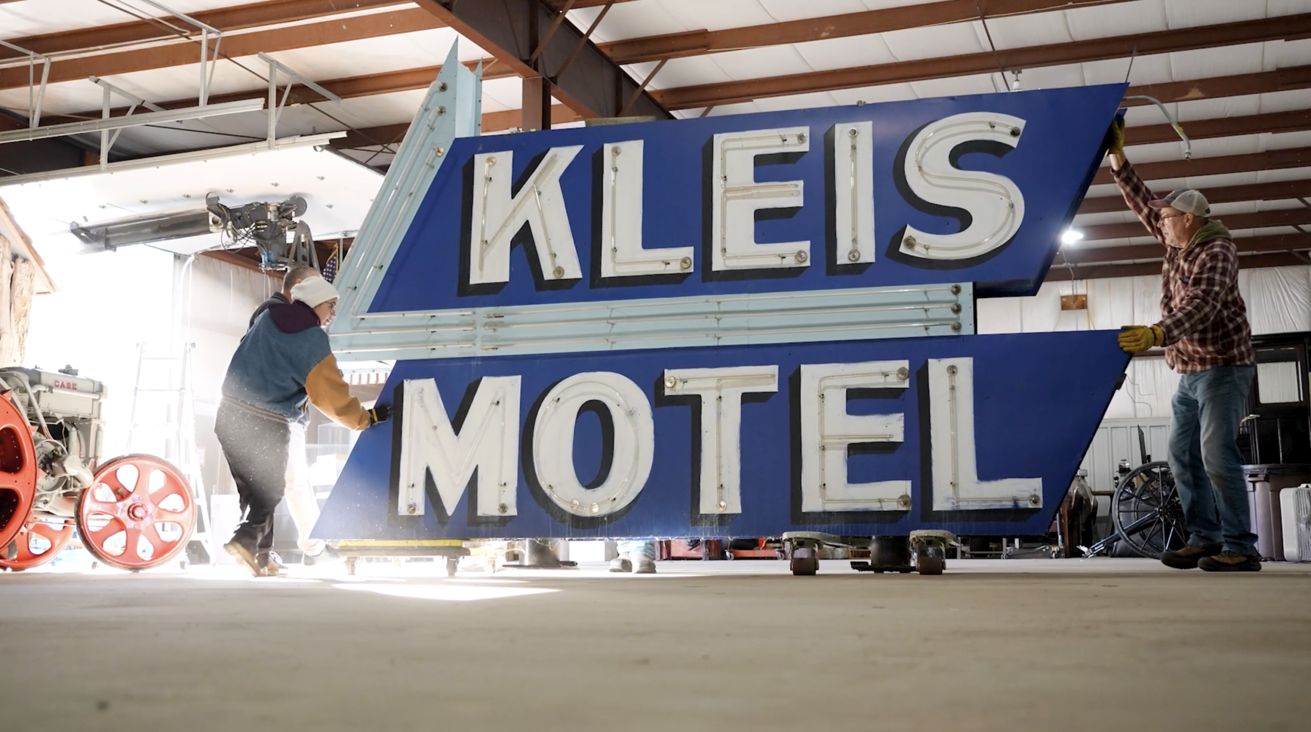 The large neon Kleis Motel sign being carefully moved into the Stearns History Museum